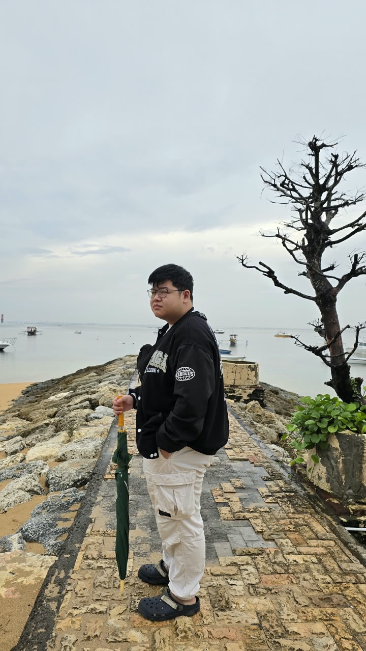 Villyan Sutanto standing on a stone jetty by the sea